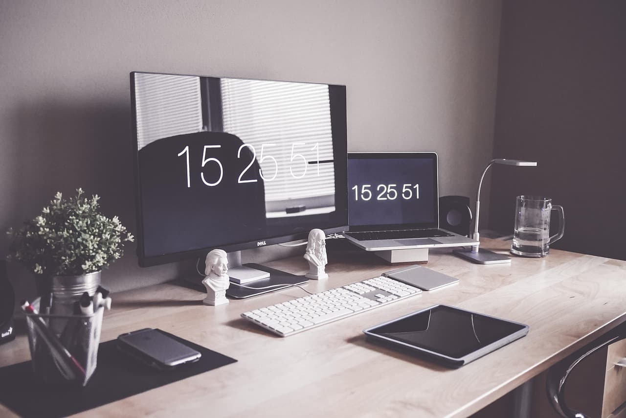 Modern workspace with multiple screens showing website design layouts and development tools