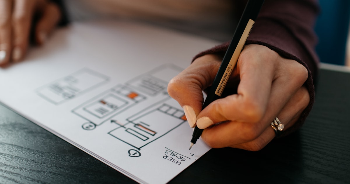 Web designer reviewing wireframes and website mockups on a desk during the design process